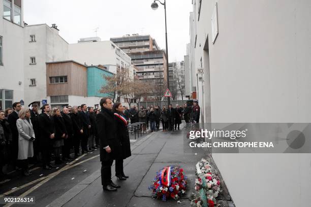 French President Emmanuel Macron and Paris mayor Anne Hidalgo observe a minute of silence outside the satirical newspaper Charlie Hebdo former...