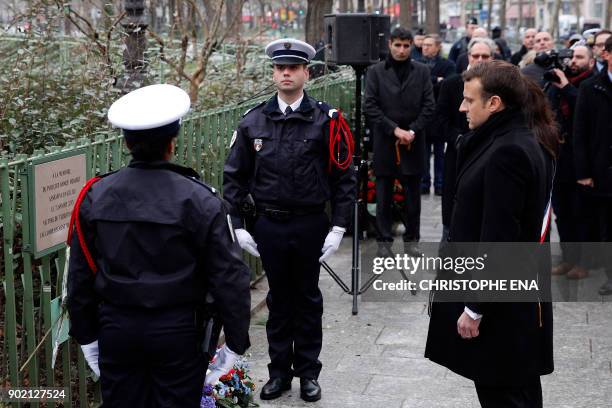 French President Emmanuel Macron observes a minute of silence in front of the plaque commemorating late police officer Ahmed Merabet to mark the...