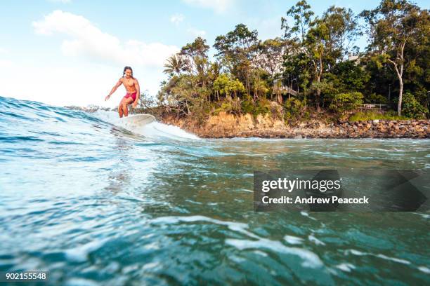 a surfer catches a wave at first point - sunshine coast australia stock pictures, royalty-free photos & images