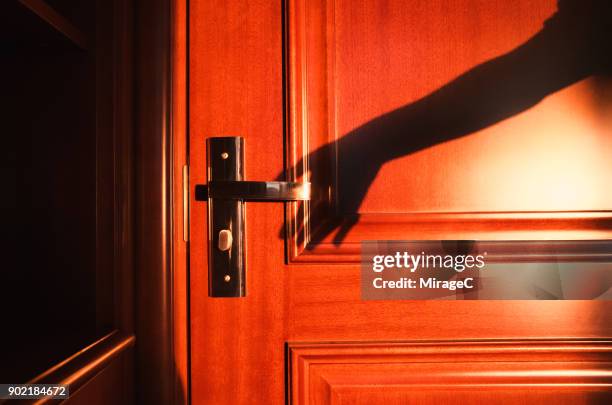 hand shadow reaching door - türklinke stock-fotos und bilder
