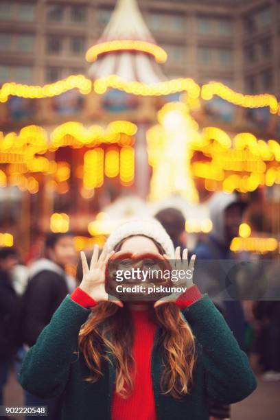 young woman with pretzel at christmas market - piskunov imagens e fotografias de stock