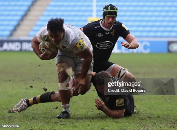 Billy Vunipola of Saracens charges away from Thomas Young and James Gaskell during the Aviva Premiership match between Wasps and Saracens at The...
