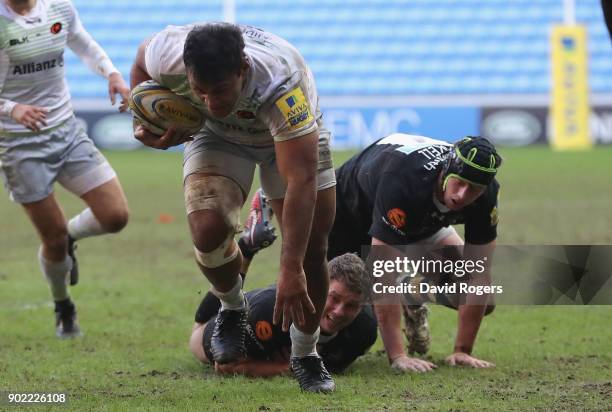 Billy Vunipola of Saracens charges away from Thomas Young and James Gaskell during the Aviva Premiership match between Wasps and Saracens at The...