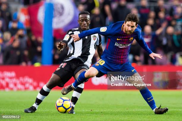 Lionel Messi of FC Barcelona fights for the ball with Emmanuel Boateng of Levante UD during the La Liga match between Barcelona and Levante at Camp...
