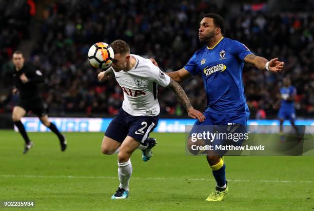 Kieran Trippier of Tottenham Hotspur heads the ball away from Andy Barcham of AFC Wimbledon during The Emirates FA Cup Third Round match between...