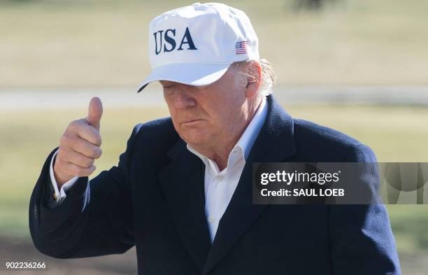 President Donald Trump gives a thumbs-up as he walks from Marine One upon arrival on the South Lawn of the White House in Washington, DC, January 7...