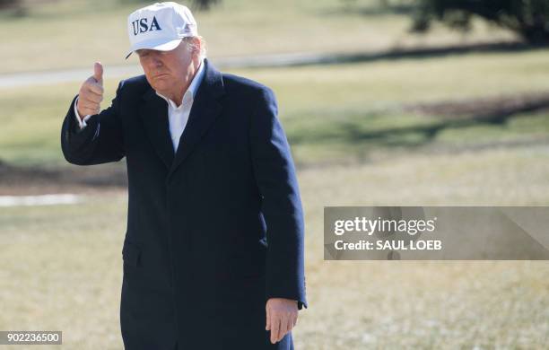 President Donald Trump gives a thumbs-up as he walks from Marine One upon arrival on the South Lawn of the White House in Washington, DC, January 7...