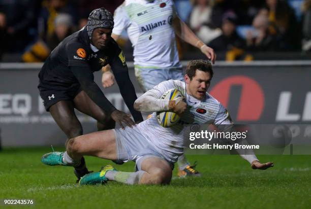 Alex Goode of Saracens scores a try despite the efforts of Christian Wade of Wasps during the Aviva Premiership match between Wasps and Saracens at...