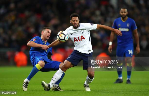 Cody McDonald of AFC Wimbledon and Mousa Dembele of Tottenham Hotspur compete for the ball during The Emirates FA Cup Third Round match between...