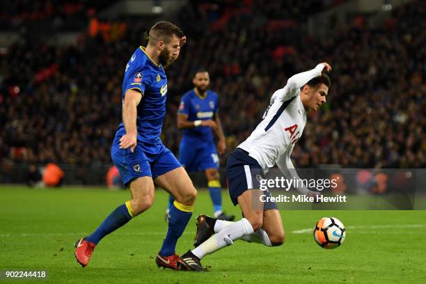 Jonathan Meades of AFC Wimbledon and Dele Alli of Tottenham Hotspur battle for the ball during The Emirates FA Cup Third Round match between...