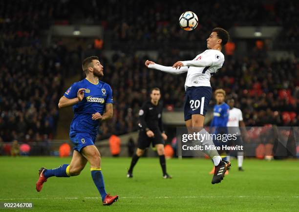 Dele Alli of Tottenham Hotspur jumps for the header during The Emirates FA Cup Third Round match between Tottenham Hotspur and AFC Wimbledon at...