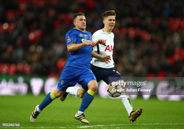 Cody McDonald of AFC Wimbledon is chased by Juan Foyth of Tottenham Hotspur during The Emirates FA Cup Third Round match between Tottenham Hotspur...