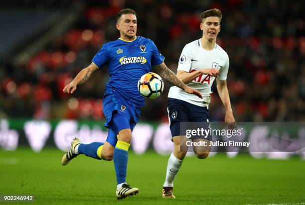 Cody McDonald of AFC Wimbledon runs for the ball with Juan Foyth of Tottenham Hotspur during The Emirates FA Cup Third Round match between Tottenham...