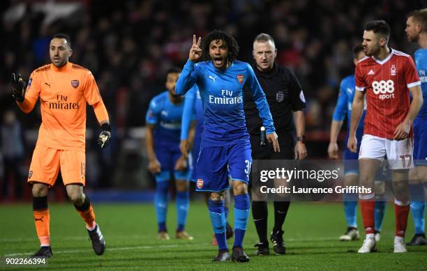 Mohamed Elneny and David Ospina of Arsenal gesture with two fingers watched by referee Jonathan Moss during The Emirates FA Cup Third Round match...