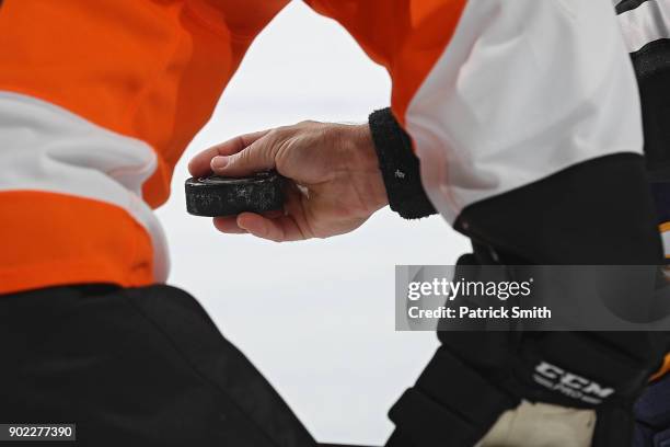 Referee holds the puck during a face-off as the Buffalo Sabres play the Philadelphia Flyers during the first period at Wells Fargo Center on January...