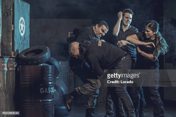 krav maga fighting group training in dark indoor urban setting - krav maga stock pictures, royalty-free photos & images