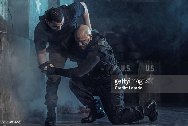 krav maga fighting duo training in dark indoor urban setting - teach to fight stock pictures, royalty-free photos & images