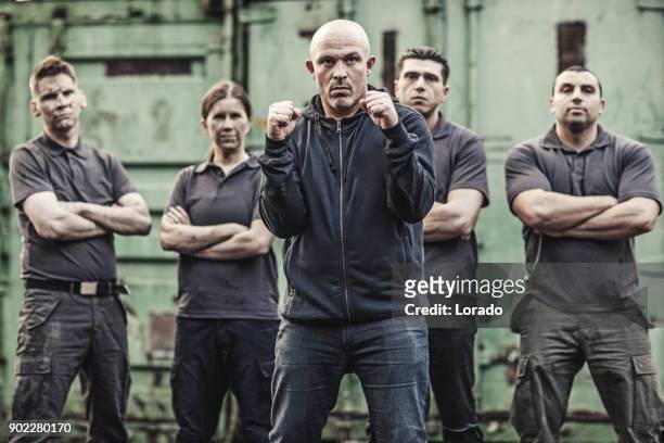 krav maga fighting group posing in grimy outdoor urban setting - committee of public security and fight stock pictures, royalty-free photos & images
