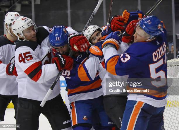 Sami Vatanen and Nico Hischier of the New Jersey Devils go up against Cal Clutterbuck and Casey Cizikas of the New York Islanders during the second...