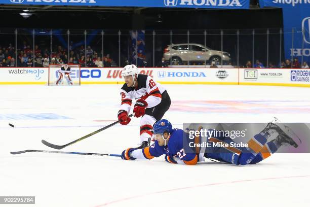 Anders Lee of the New York Islanders and Steven Santini of the New Jersey Devils persue the puck at Barclays Center on January 7, 2018 in New York...