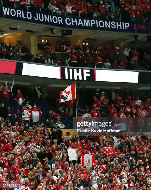 Fans raise the flag of Canada after a goal against Sweden during the Gold medal game of the IIHF World Junior Championship at KeyBank Center on...