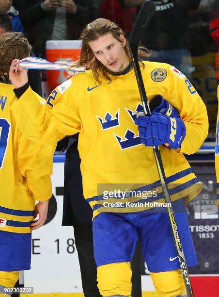 Axel Jonsson Fjällby of Sweden takes his silver medal off after losing against Canada during the Gold medal game of the IIHF World Junior...