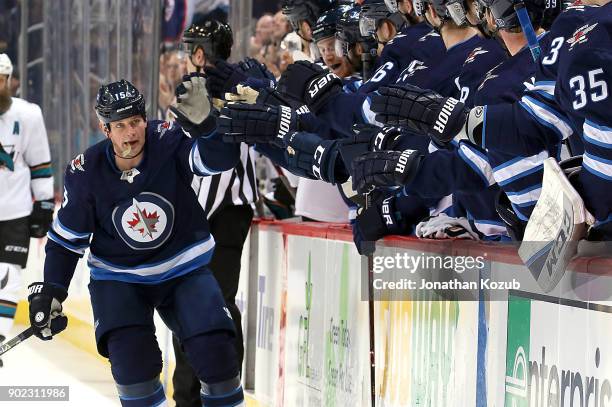 Matt Hendricks of the Winnipeg Jets celebrates his first period goal against the San Jose Sharks with teammates at the bench at the Bell MTS Place on...