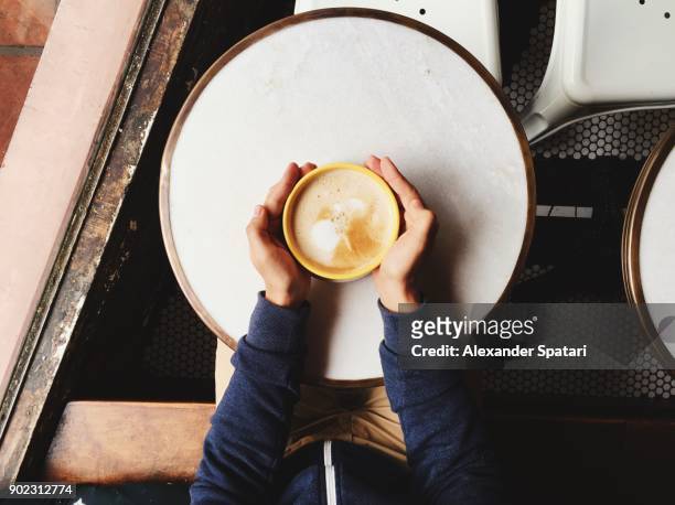 personal perspective of a man holding cappuccino bowl with two hands - coffee above stock-fotos und bilder