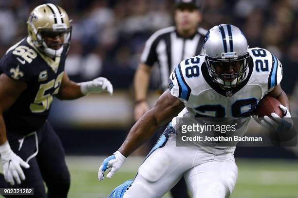 Jonathan Stewart of the Carolina Panthers runs with the ball as Craig Robertson of the New Orleans Saints defends during the first half of the NFC...