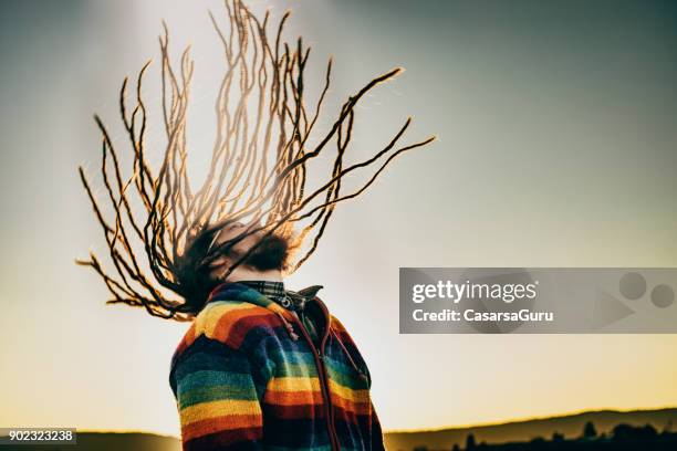 kaukasische jongeman swingende dreadlocks - dreadlocks stockfoto's en -beelden