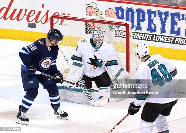 Marko Dano of the Winnipeg Jets tips the puck in front of goaltender Martin Jones of the San Jose Sharks during second period action at the Bell MTS...