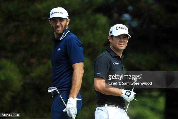 Dustin Johnson of the United States and Brian Harman of the United States look on from the second tee during the final round of the Sentry Tournament...