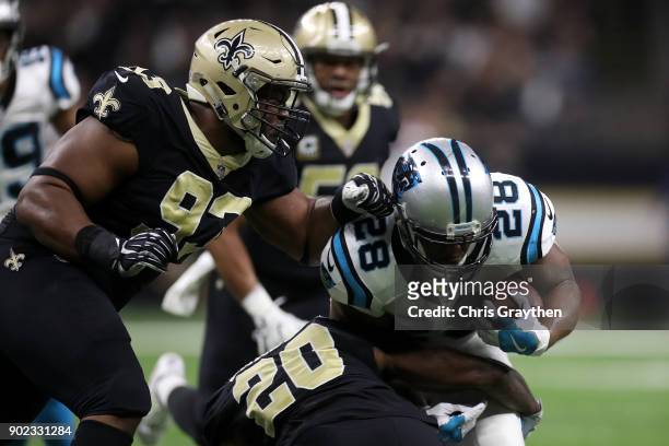 Jonathan Stewart of the Carolina Panthers is tackled by Ken Crawley of the New Orleans Saints at the Mercedes-Benz Superdome on January 7, 2018 in...