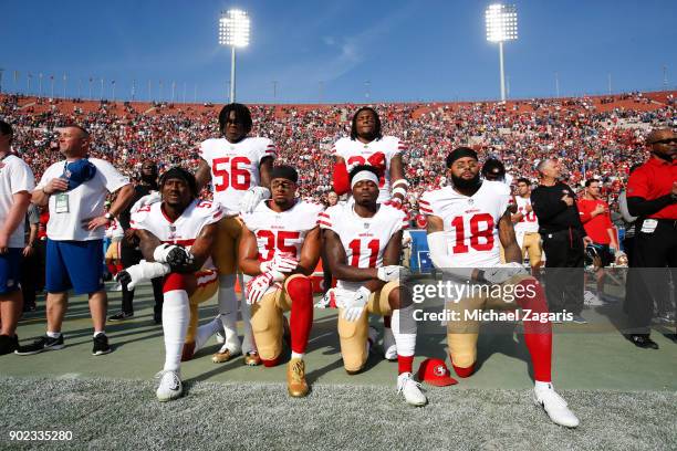 Eli Harold, Eric Reid, Marquise Goodwin and Louis Murphy of the San Francisco 49ers kneel during the anthem as Reuben Foster and Adrian Colbert stand...