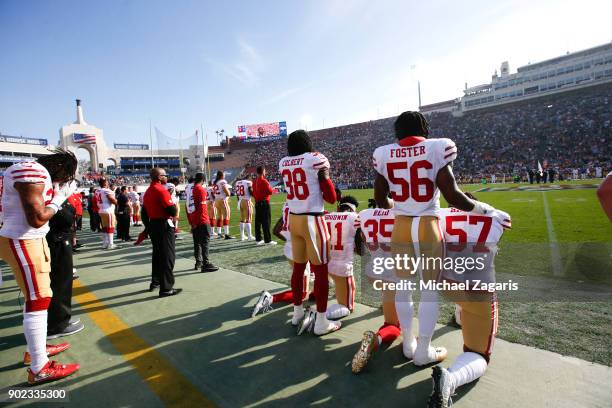 Eli Harold, Eric Reid, Marquise Goodwin and Louis Murphy of the San Francisco 49ers kneel during the anthem as Reuben Foster and Adrian Colbert stand...