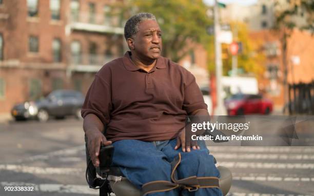 portret van de positieve, optimistische uitgeschakeld zwarte man, verlamd veteraan die zittend in de rolstoel - the bronx stockfoto's en -beelden