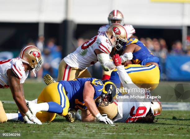 Brock Coyle and Sheldon Day of the San Francisco 49ers tackle Malcolm Brown of the Los Angeles Rams during the game at Los Angeles Memorial Coliseum...
