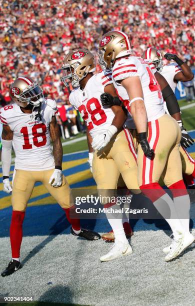 Carlos Hyde of the San Francisco 49ers is congratulated by teammates after scoring on a 5-yard touchdown run during the game against the Los Angeles...