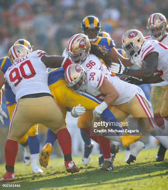 Earl Mitchell and Brock Coyle of the San Francisco 49ers tackle Malcolm Brown of the Los Angeles Rams during the game at Los Angeles Memorial...