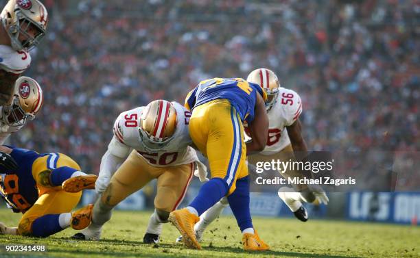 Brock Coyle of the San Francisco 49ers tackles Malcolm Brown of the Los Angeles Rams during the game at Los Angeles Memorial Coliseum on December 31,...