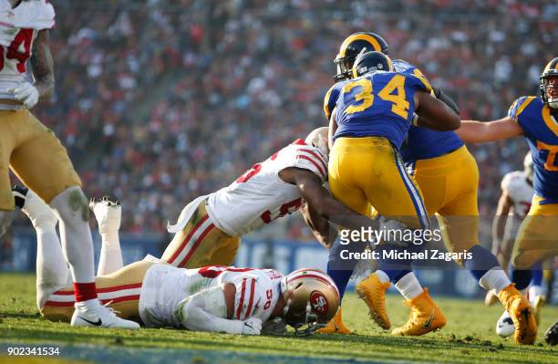 Reuben Foster of the San Francisco 49ers tackles Malcolm Brown of the Los Angeles Rams during the game at Los Angeles Memorial Coliseum on December...