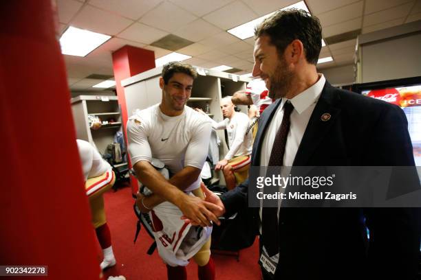 Jimmy Garoppolo and Vice President of Player Personnel Adam Peters of the San Francisco 49ers celebrate in the locker room following the game against...