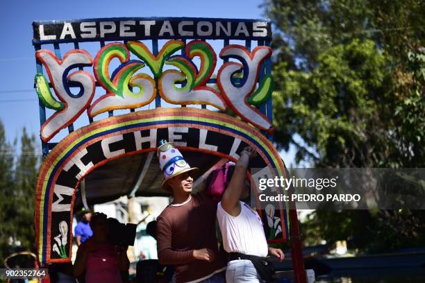 Visitors party on board of a "trajinera" -traditional flat-bottomed river boat- at Xochimilco natural reserve in Mexico City on January 7, 2018....