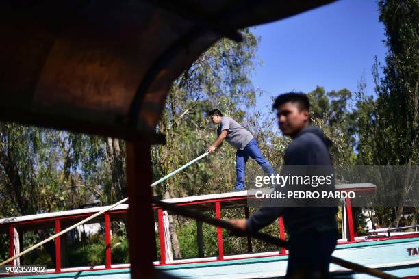 Rowers are seen on board of their "trajineras" -traditional flat-bottomed river boats- at Xochimilco natural reserve in Mexico City on January 7,...