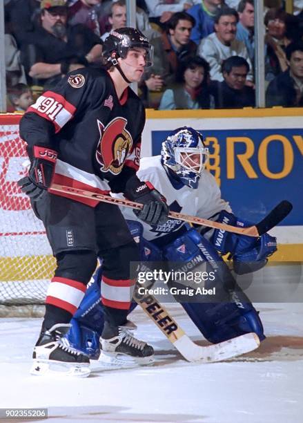 Alexandre Dangle of the Ottawa Senators skates against Damian Rhodes of the Toronto Maple Leafs during NHL game action on December 5, 1995 at Maple...