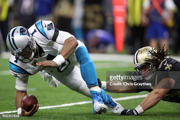 Cam Newton of the Carolina Panthers avoids a tackle by Tyeler Davison of the New Orleans Saints at the Mercedes-Benz Superdome on January 7, 2018 in...