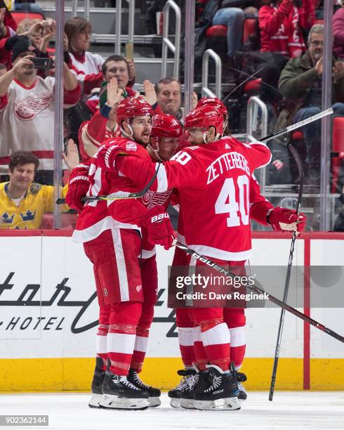 Gustav Nyquist of the Detroit Red Wings celebrates his second period goal with teammates Xavier Ouellet and Henrik Zetterberg during an NHL game...