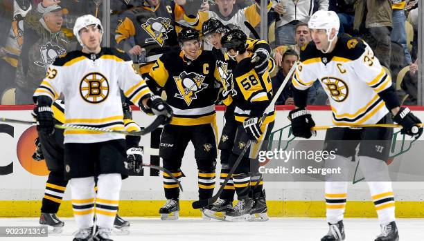 Evgeni Malkin of the Pittsburgh Penguins celebrates with Sidney Crosby and Kris Letang after scoring the power play in the second period against...