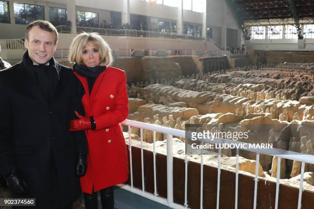 French President Emmanuel Macron and his wife Brigitte Macron pose for photos next to the famous terracotta warriors during a visit to the northern...