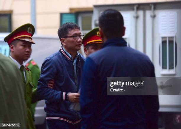 Trinh Xuan Thanh , former oil tycoon who was reportedly kidnapped from Berlin by Vietnamese Security, is lead by policemen to the courtroom at Hanoi...